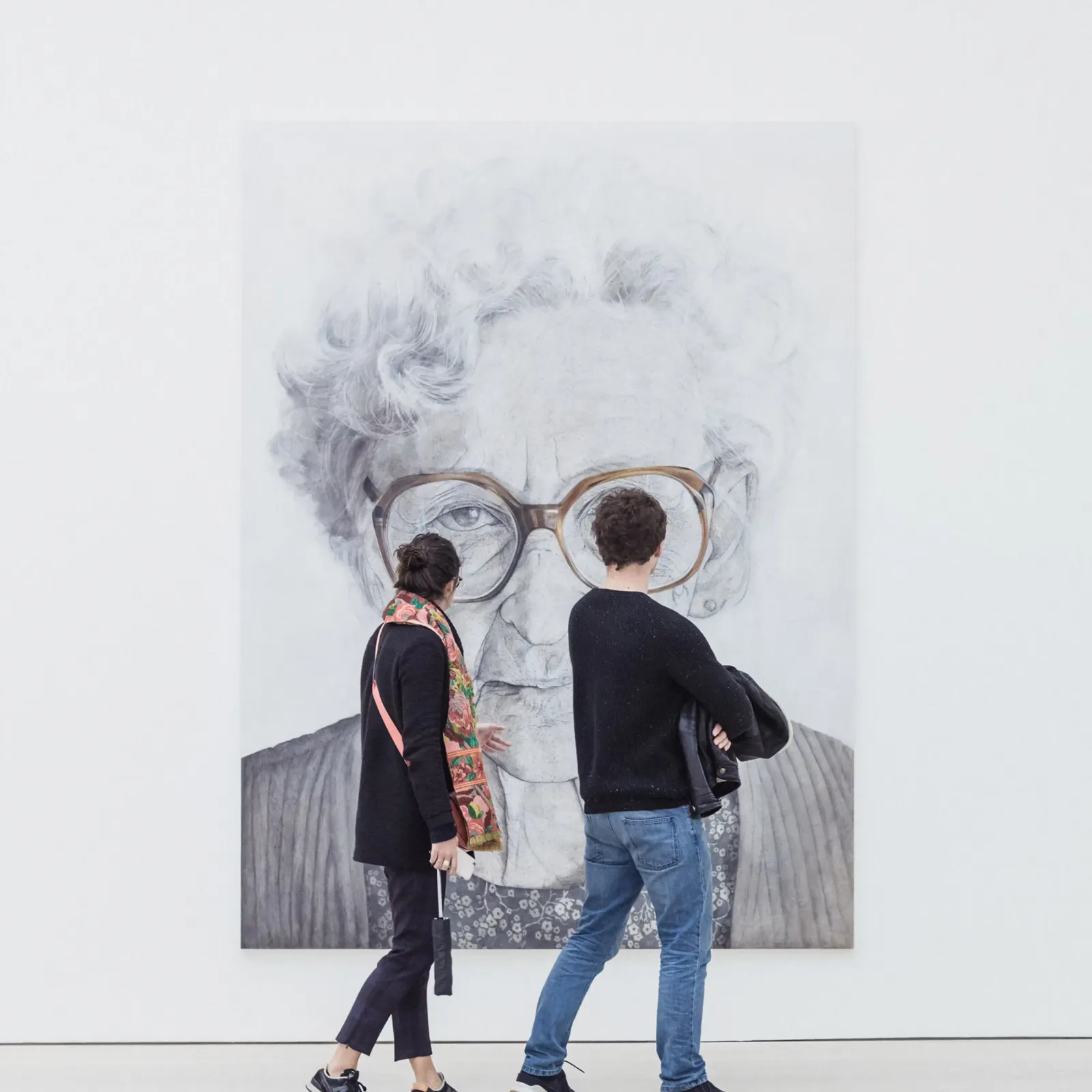 Two people looking at an artwork in a gallery space.